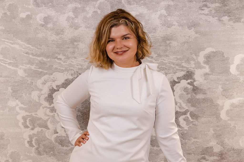 A woman (Catherine) smiling in a white dress.