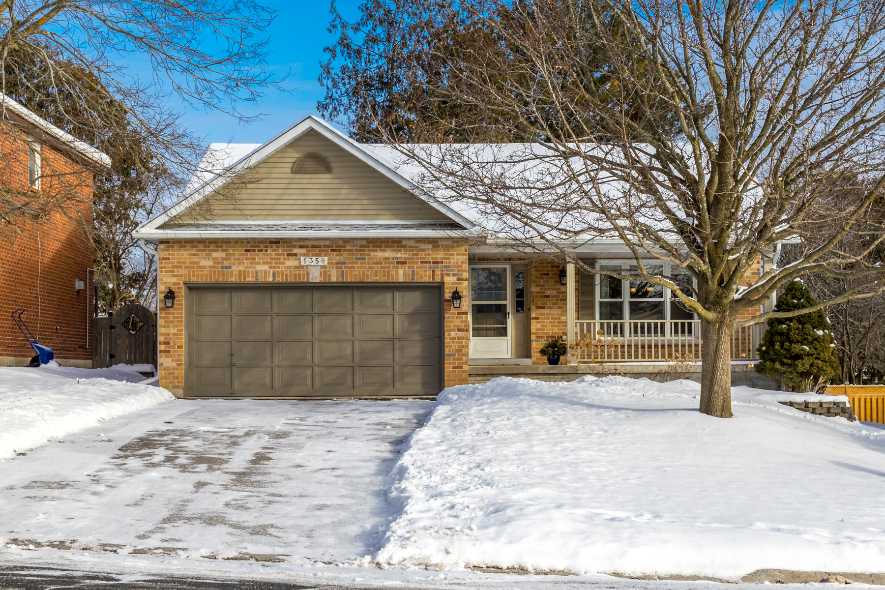 red brick bungalow with attached 2-car garage in the wintertime